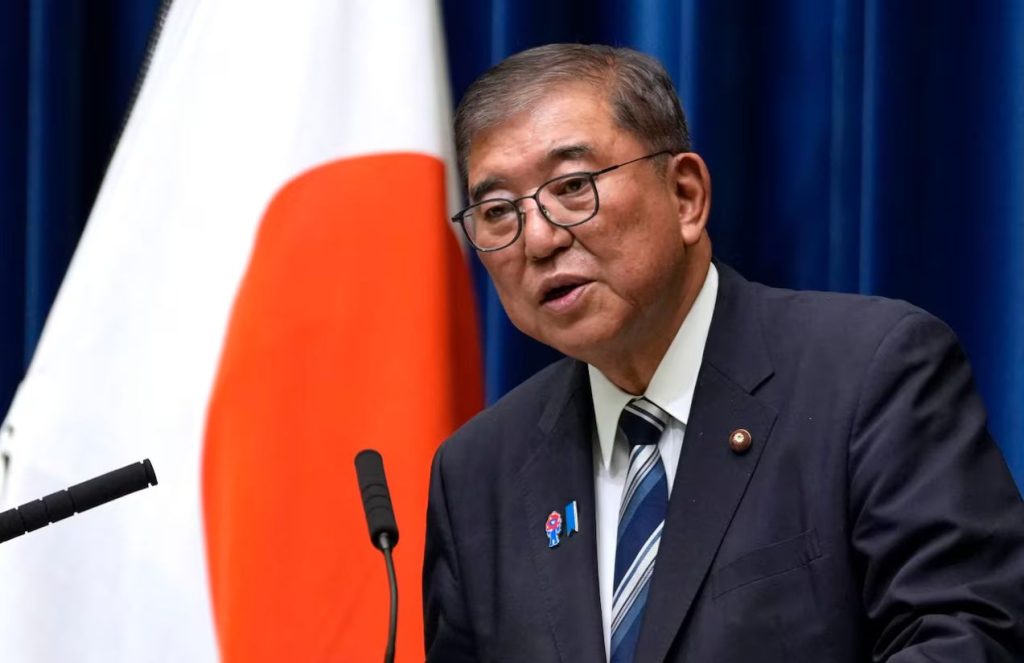 The former Japanese prime minister speaking in public wearing an elegant suit with a tie