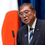 The former Japanese prime minister speaking in public wearing an elegant suit with a tie