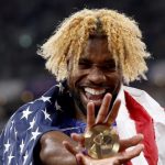 The American runner with wild blond hair celebrating with his gold medal in hand