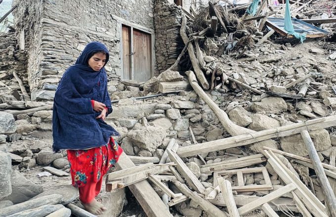 A woman walking over the rubble of a building in Afghanistan