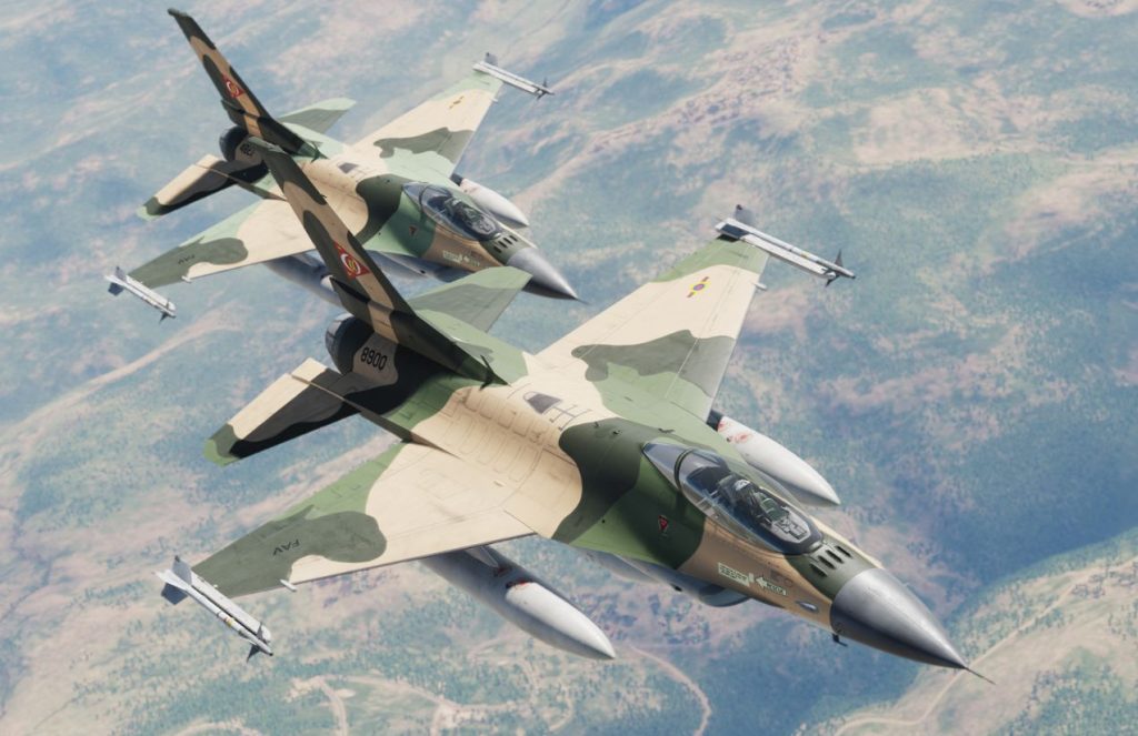 Two Venezuelan F-16s in camouflage flying across the wide blue sky