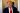 Donald Trump giving a conference in front of the cameras wearing a beautiful black suit