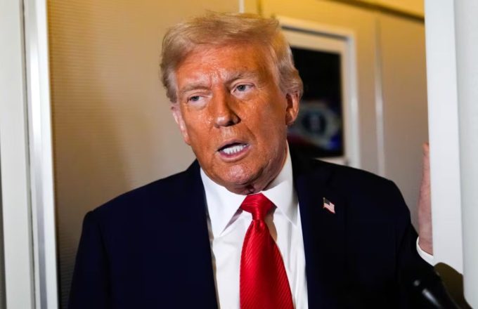 Donald Trump giving a conference in front of the cameras wearing a beautiful black suit