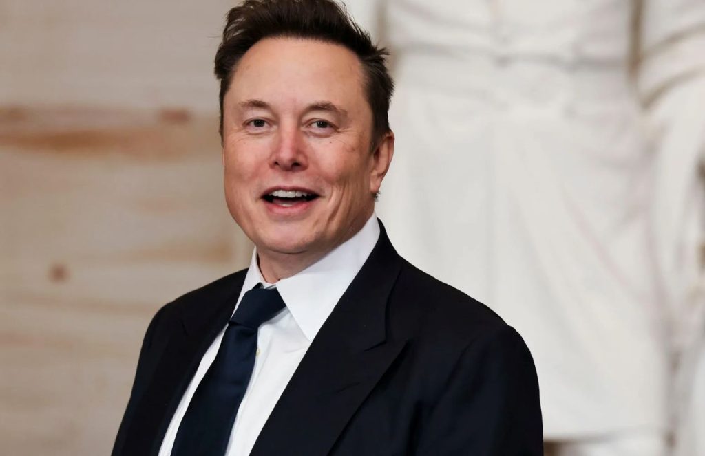 Elon Musk wearing an elegant black suit while posing for the cameras