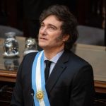 Javier Milei in the chamber wearing a tuxedo, with the Argentine flag draped from his shoulder down to his hip