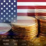 The flag of the United States alongside some coins and economic indicators