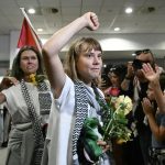 The activist arriving at an airport where many of her supporters are waiting for her, looking very happy