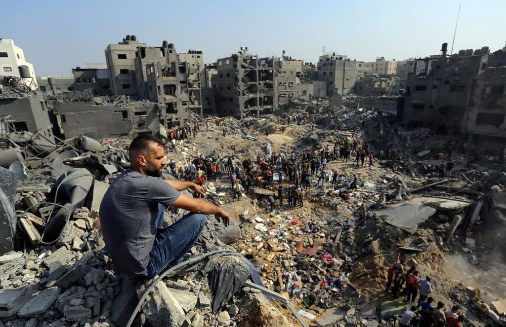 Many people gathered in a destroyed area waiting to be freed
