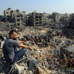 Many people gathered in a destroyed area waiting to be freed