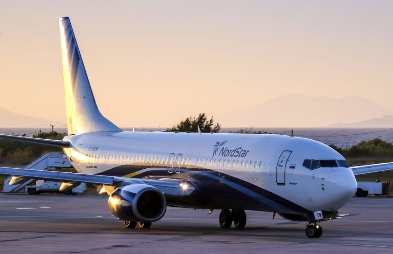 A large airplane parked on a runway after an emergency landing at an airport