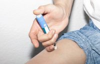 A person injecting some type of medication into their leg