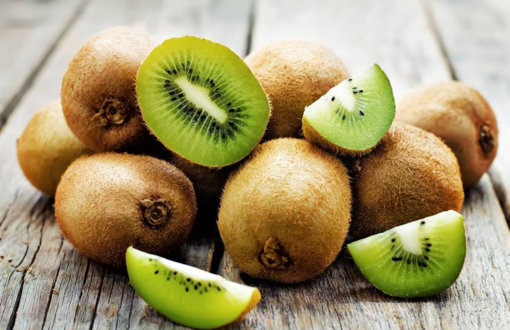 Several kiwis piled up, with only the ones on top cut in half