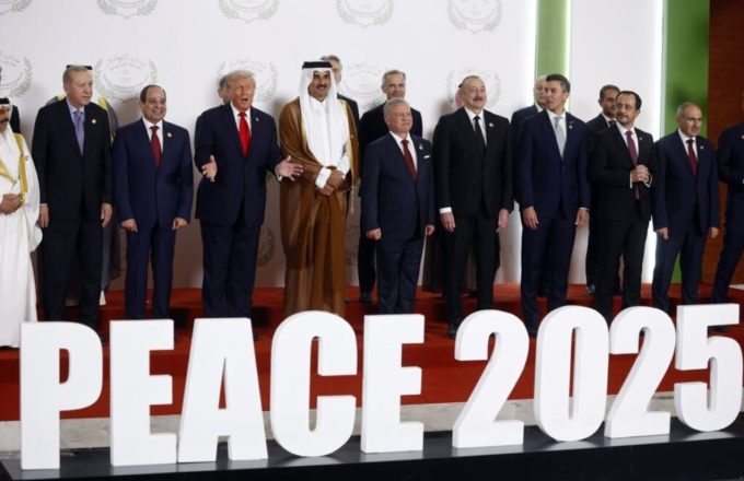The President of the United States posing in front of a sign that reads “peace,” standing alongside other world leaders