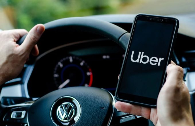 Uber will pay its drivers to train artificial intelligence: the job of the future has arrived A driver sitting in his car holding his phone with the Uber app open