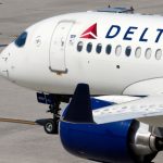A Delta airplane parked at an airport waiting for passengers