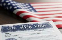 A wooden table with a U.S. flag and one of the types of visas the country offers placed on top