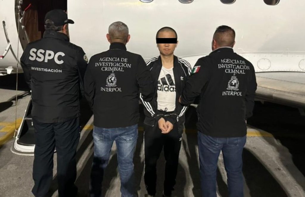 Zhi Dong Zhang arrested, alleged international operator in cocaine and fentanyl trafficking in the United States The Chinese national being escorted by three agents as he is about to board a plane for extradition