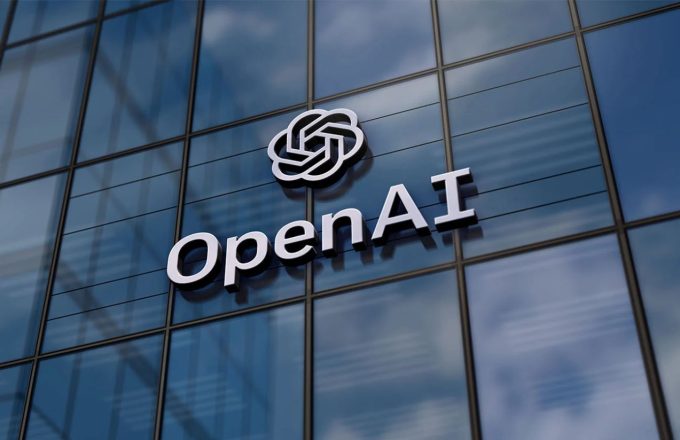 A large building window with the word “OpenAI” written across it in white letters