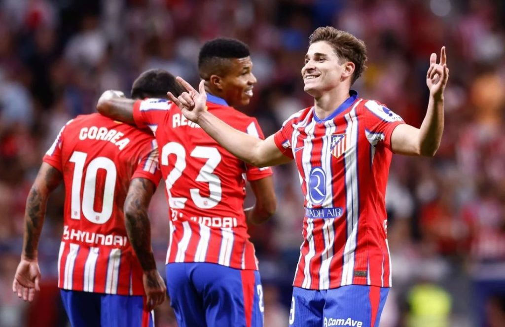 Julián Álvarez celebrating one of his goals with two teammates
