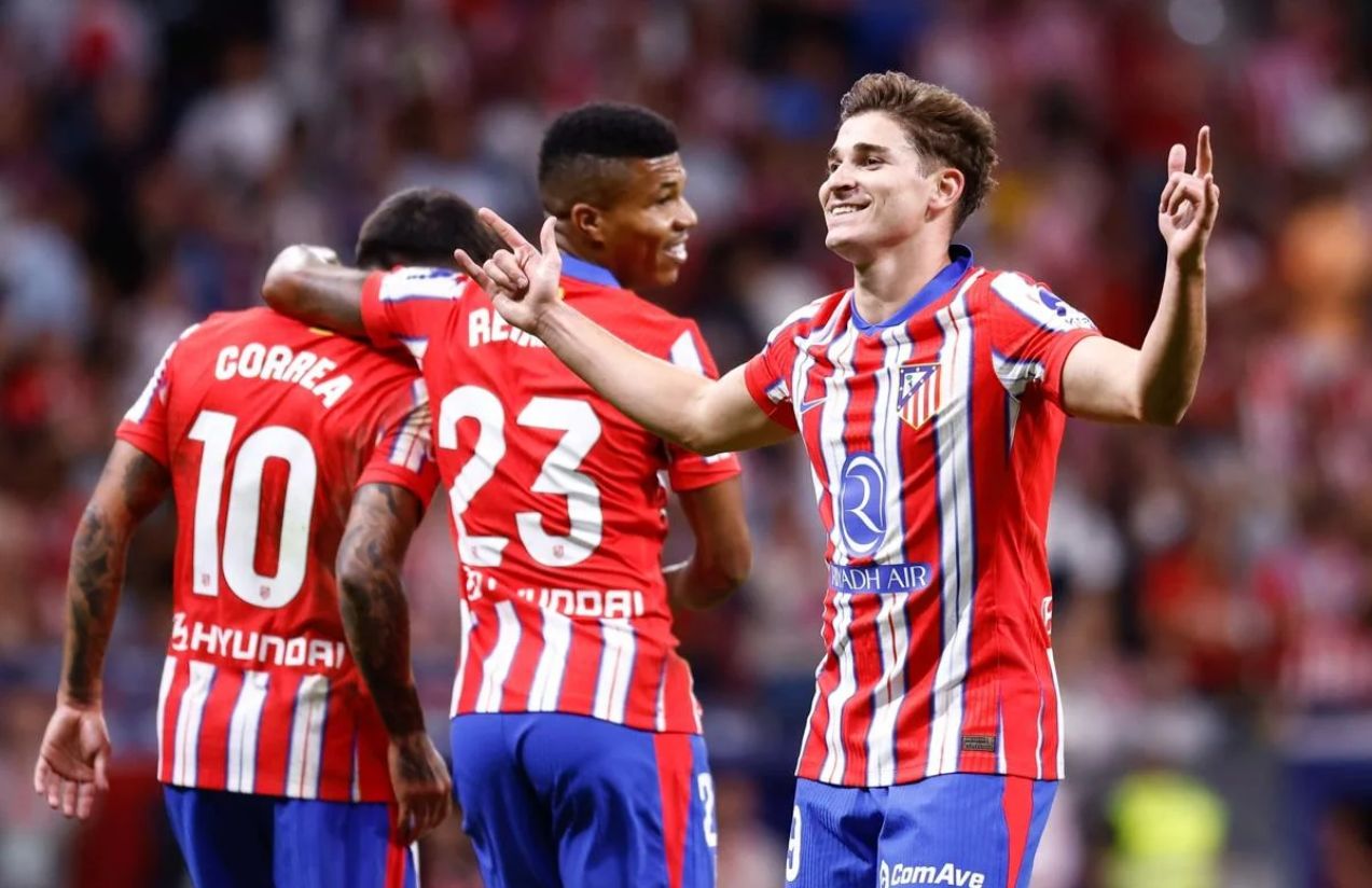Julián Álvarez celebrating one of his goals with two teammates