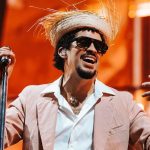 Bad Bunny happily holding the microphone while putting on an incredible show