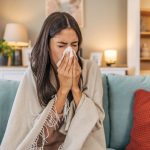 A woman blowing her nose in the middle of a strong cold