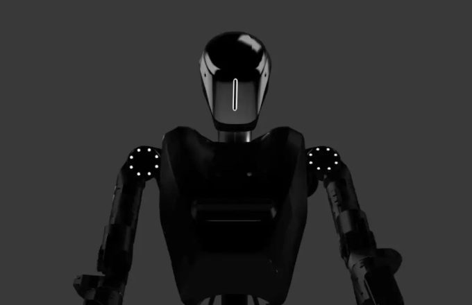 An all-black robot standing upright against a gray background