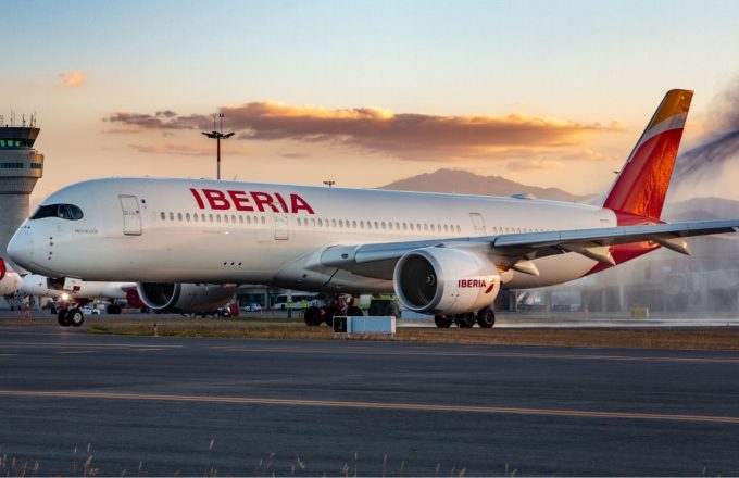A plane from the Iberia airline, painted in its characteristic white with a red tail, waiting for clearance to take off