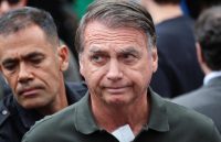 Bolsonaro looking worried while walking under arrest by the police