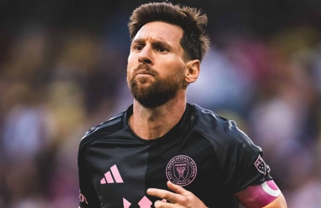 Lionel Messi walking on the field with his head held high and a very serious expression