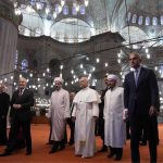 The Pope, dressed in white, walking down the steps of the Blue Mosque alongside Turkey’s religious leaders