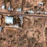 A satellite image of the town of El Fasher, showing visible traces of red stains