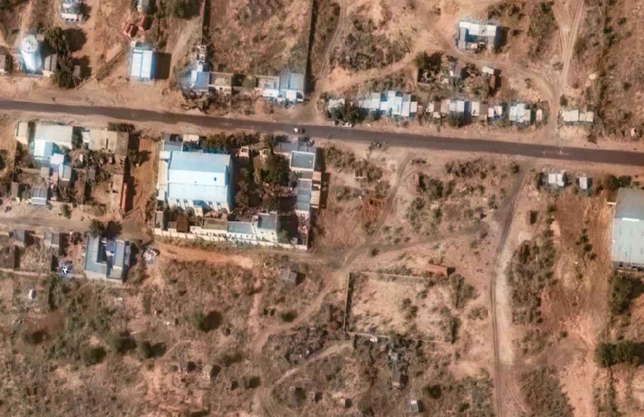 A satellite image of the town of El Fasher, showing visible traces of red stains