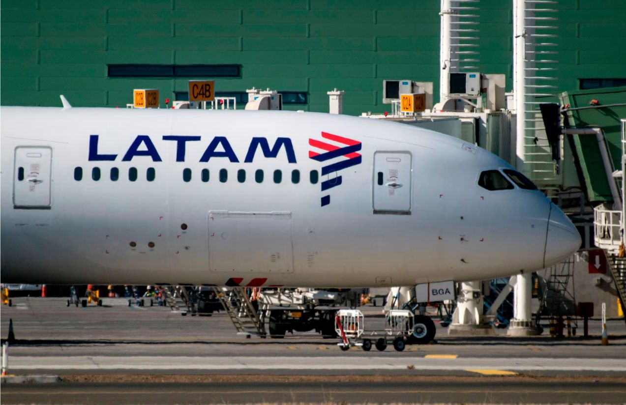 A LATAM airplane parked at an airport waiting for its passengers