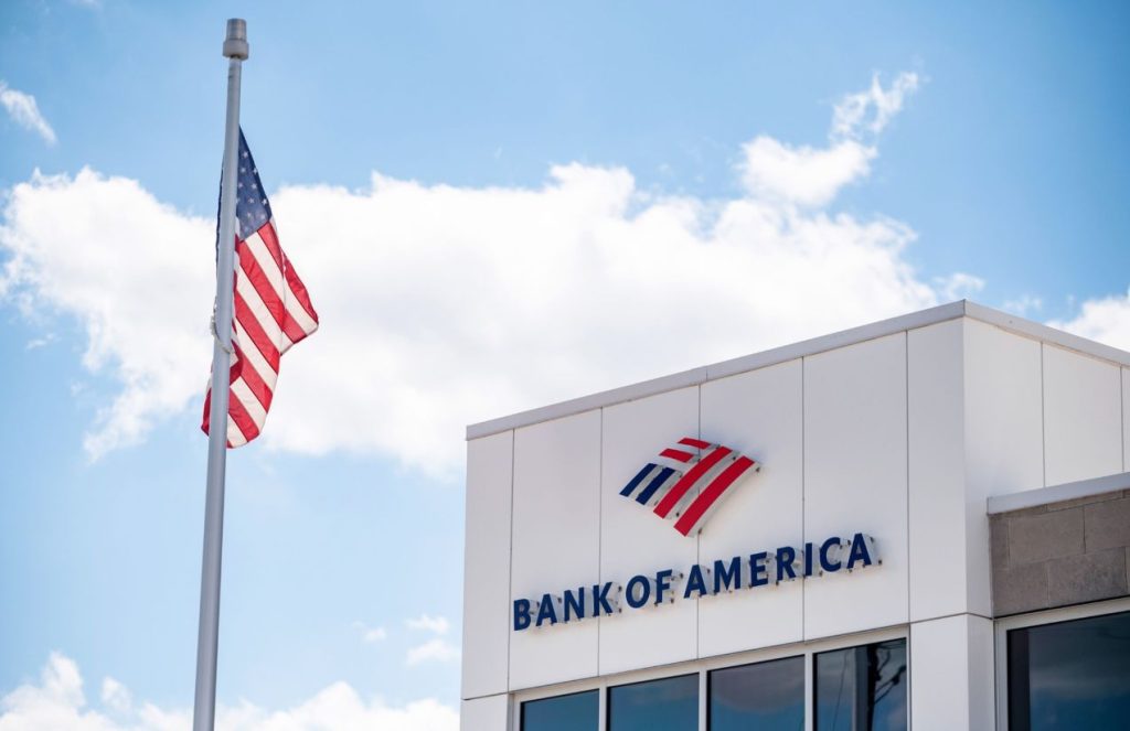 The 7 best banks for immigrants in the United States A building with the words “Bank of America” at the top, and next to it, a United States flag waving beside it