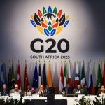 Several representatives of the G20 countries sitting at a table with their respective flags behind them