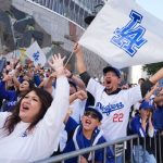 Many Dodgers fans celebrating excitedly during the team’s parade after winning the baseball championship