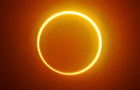 A sun covered by the moon, leaving a city in darkness