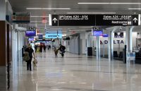 hallway in an airport crowded with people searching for their flights