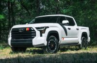 A white Toyota Tundra parked in the middle of a forest for a photo shoot