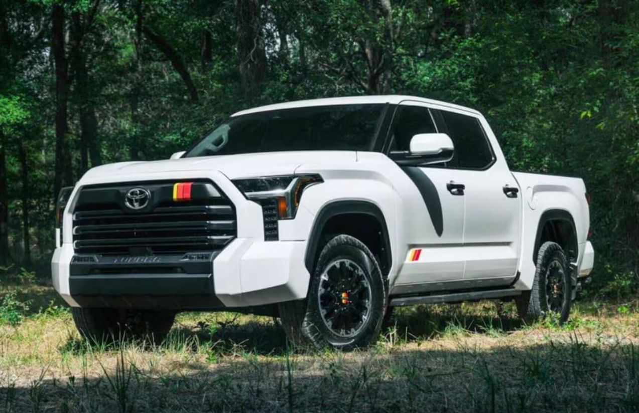 A white Toyota Tundra parked in the middle of a forest for a photo shoot
