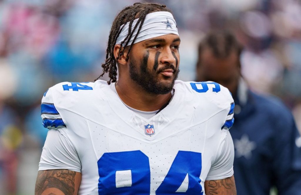 The young player standing on a football field wearing the white Dallas Cowboys uniform