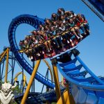 Many people riding in a roller coaster car, all happy and screaming with excitement