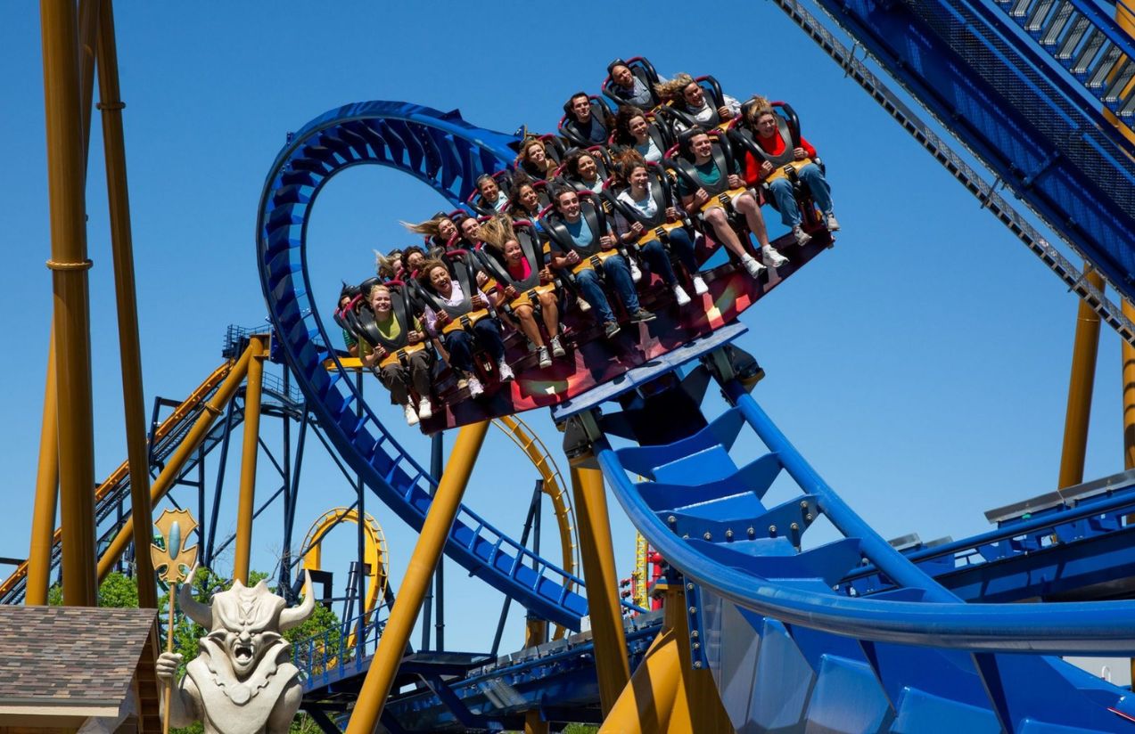 Many people riding in a roller coaster car, all happy and screaming with excitement