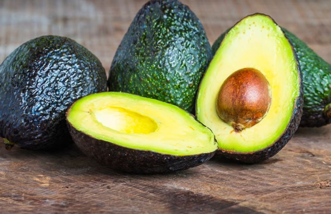A halved avocado on a wooden table