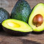 A halved avocado on a wooden table