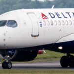 A Delta Air Lines aircraft parked at an airport while its passengers disembark
