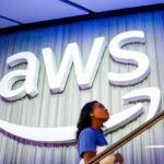 A white AWS sign on a large wall with a staircase in front of it