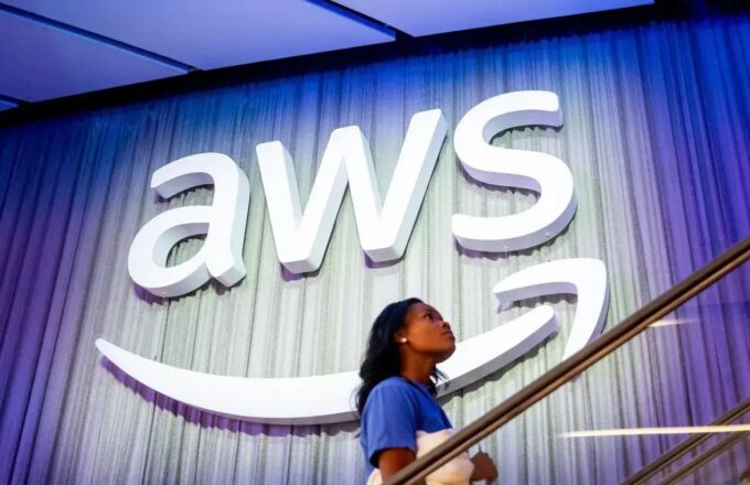 A white AWS sign on a large wall with a staircase in front of it