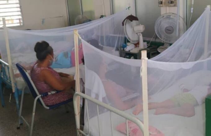 A person taking care of someone who is hospitalized on a stretcher due to dengue